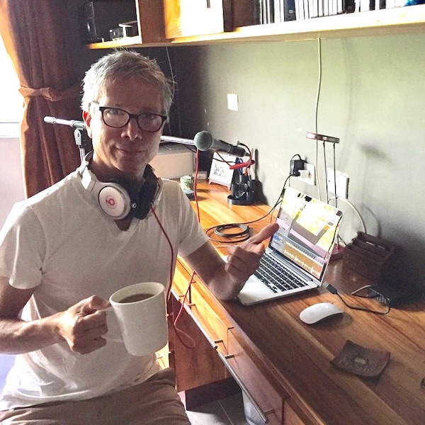 Robonzo with podcasting gear and coffee, wearing white tee-shirt and glasses, Why I Podcast