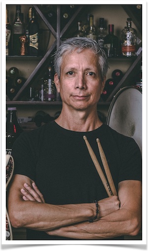 Robonzo (Roberto) with drum sticks wearing black tee