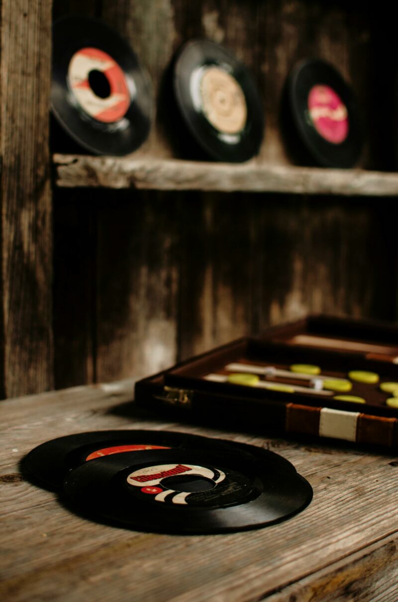 Old vinyl discs and wooden backgammon placed on shabby lumber table